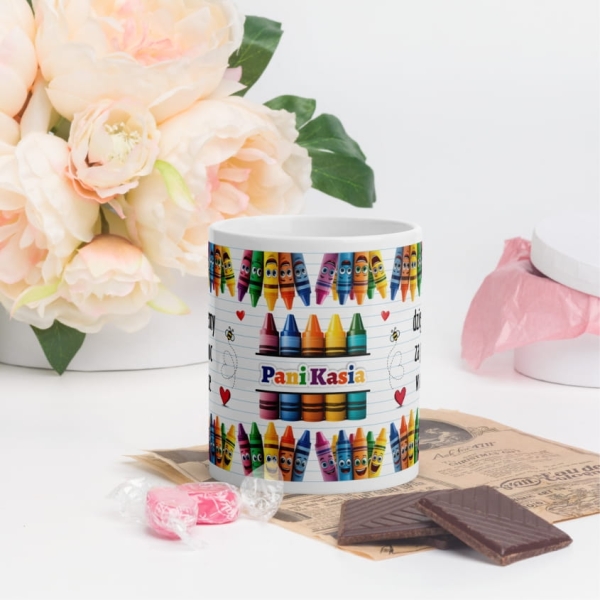 Biały kubek jako podziękowanie dla nauczyciela z grafiką kredek świecowych Mega Prezencik